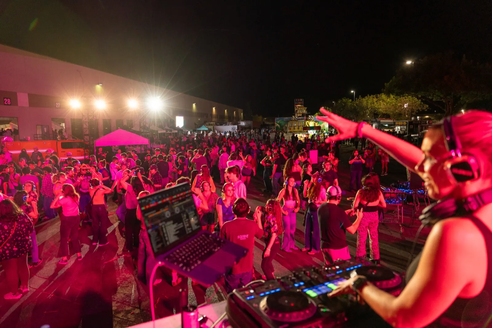 DJ Lyndsay Brown pointing out to a packed outdoor dance floor at night