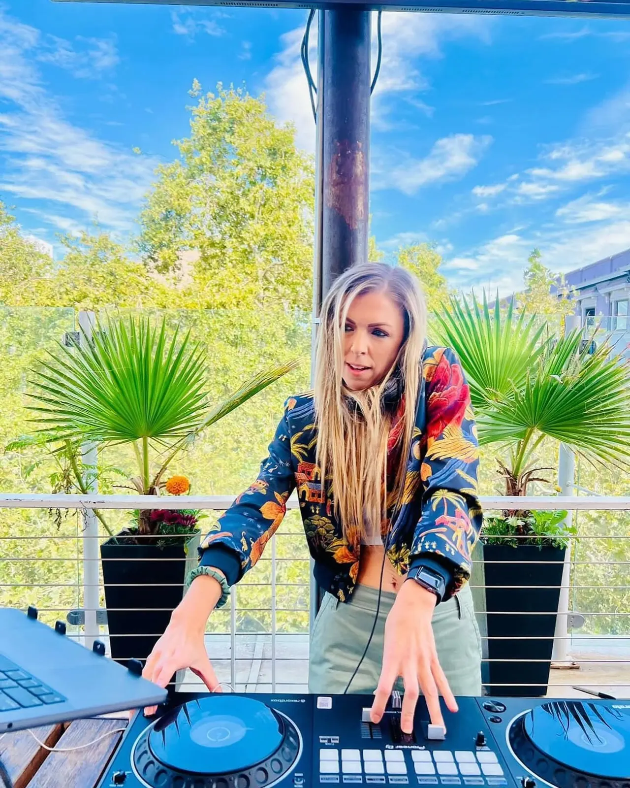 DJ Lyndsay Brown mixing on a sunny rooftop terrace