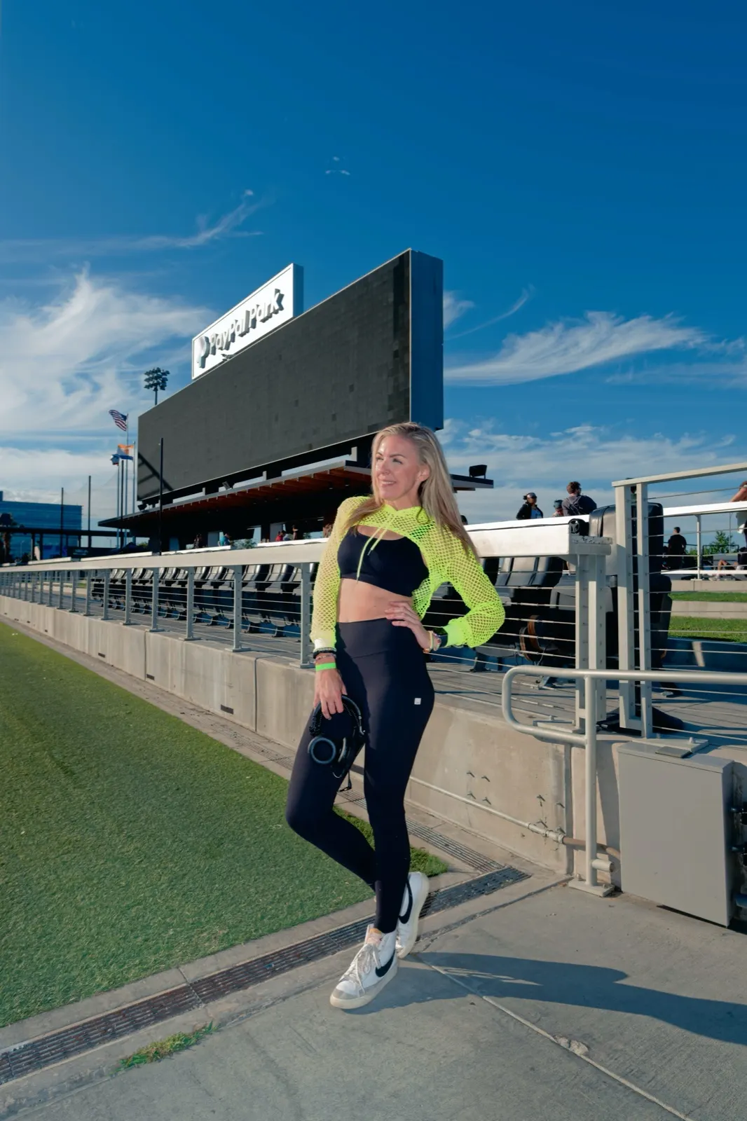 DJ Lyndsay Brown on the concourse of a stadium beside the field